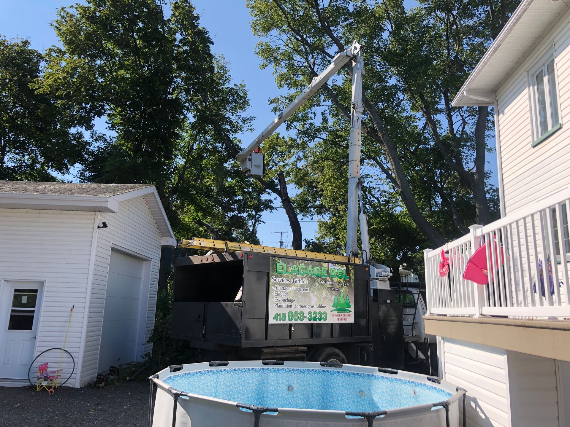 Une piscine est devant une maison avec une grue en arrière-plan.