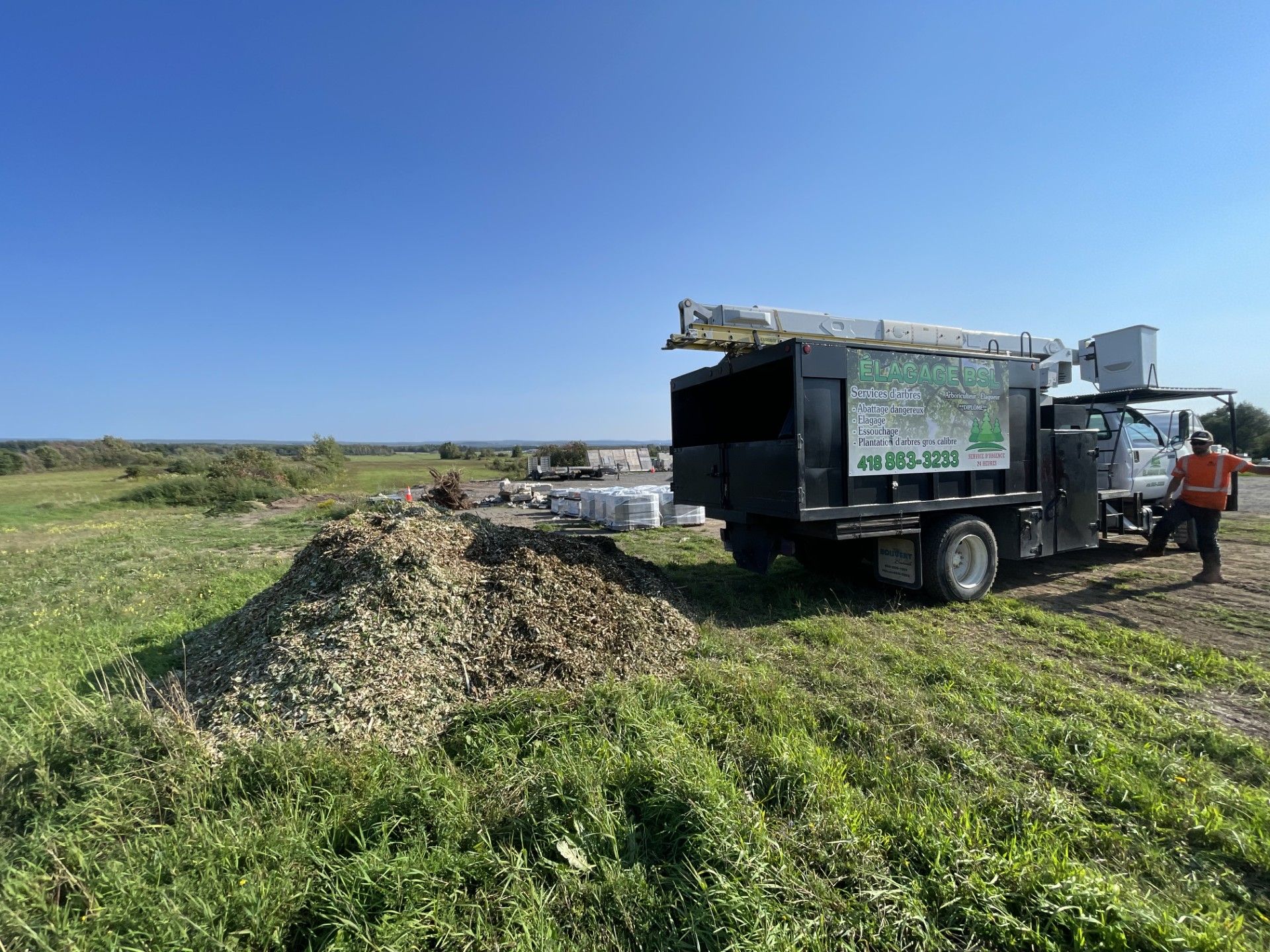 Un homme se tient à côté d'un camion dans un champ.