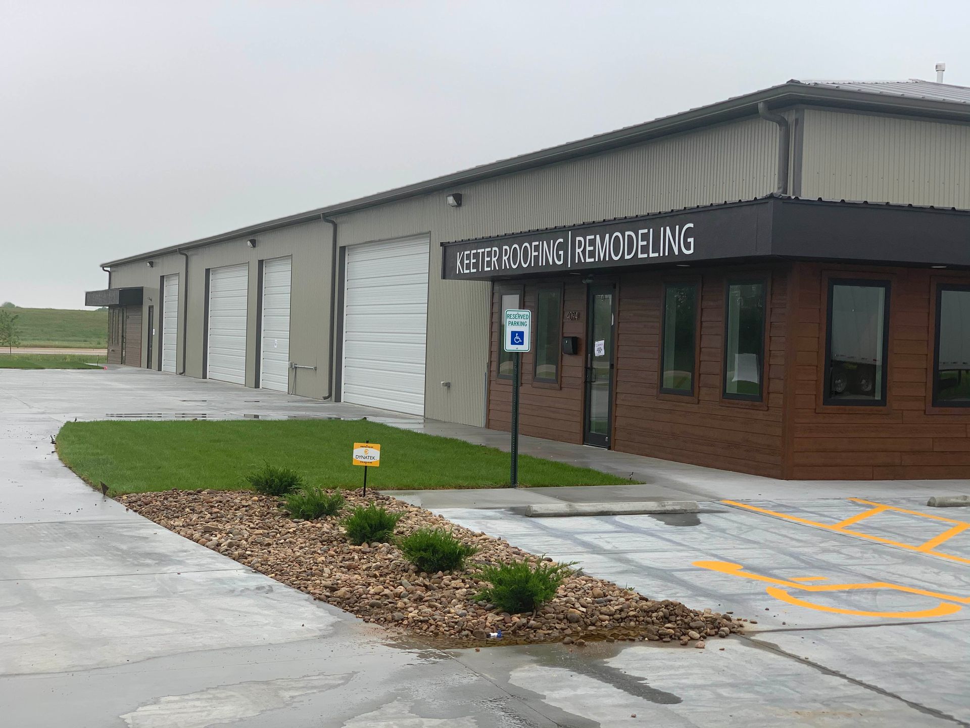 A large building with a lot of windows is sitting in a gravel lot