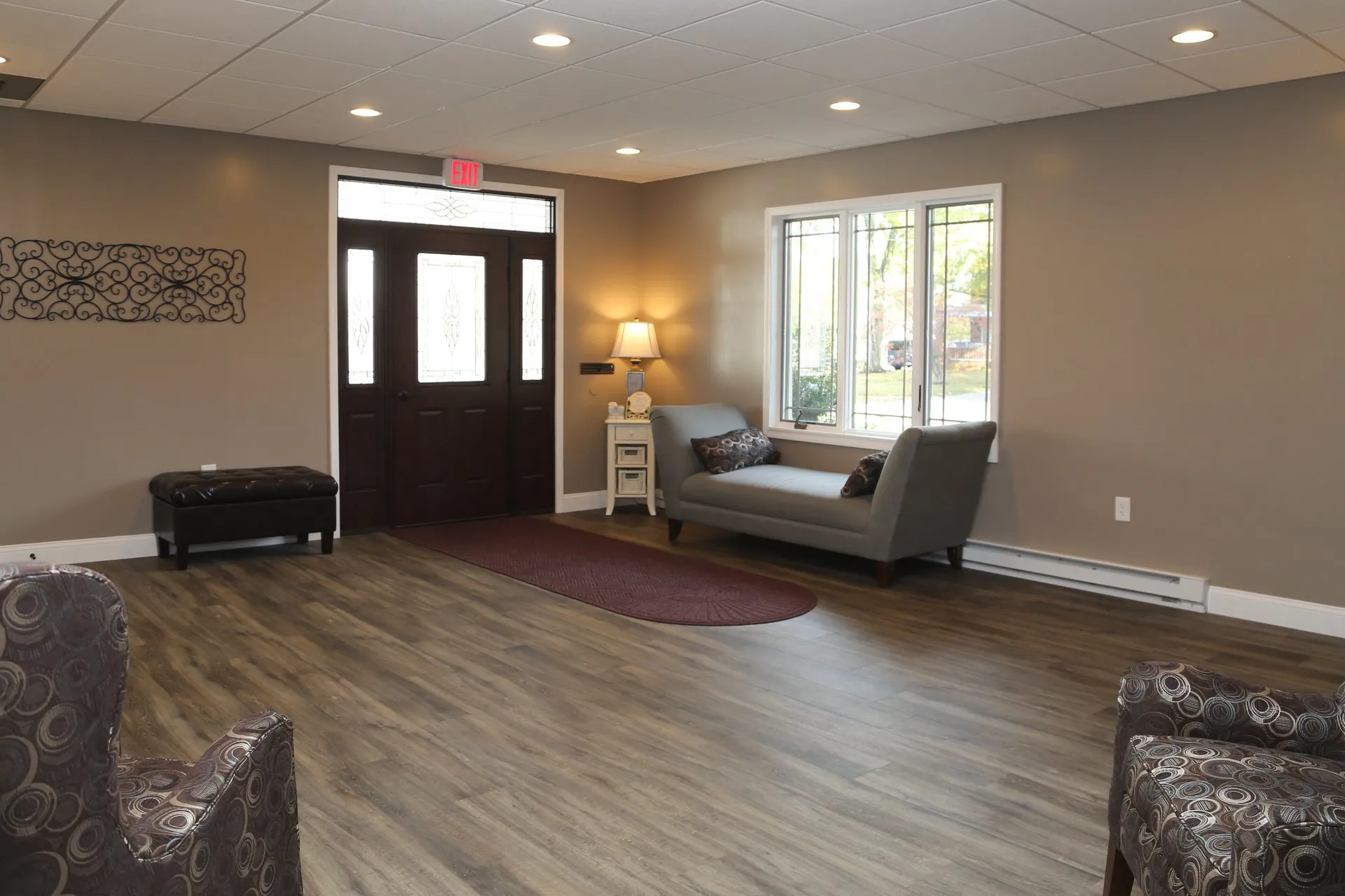 funeral home facilities room with exit door and a sofa on the side