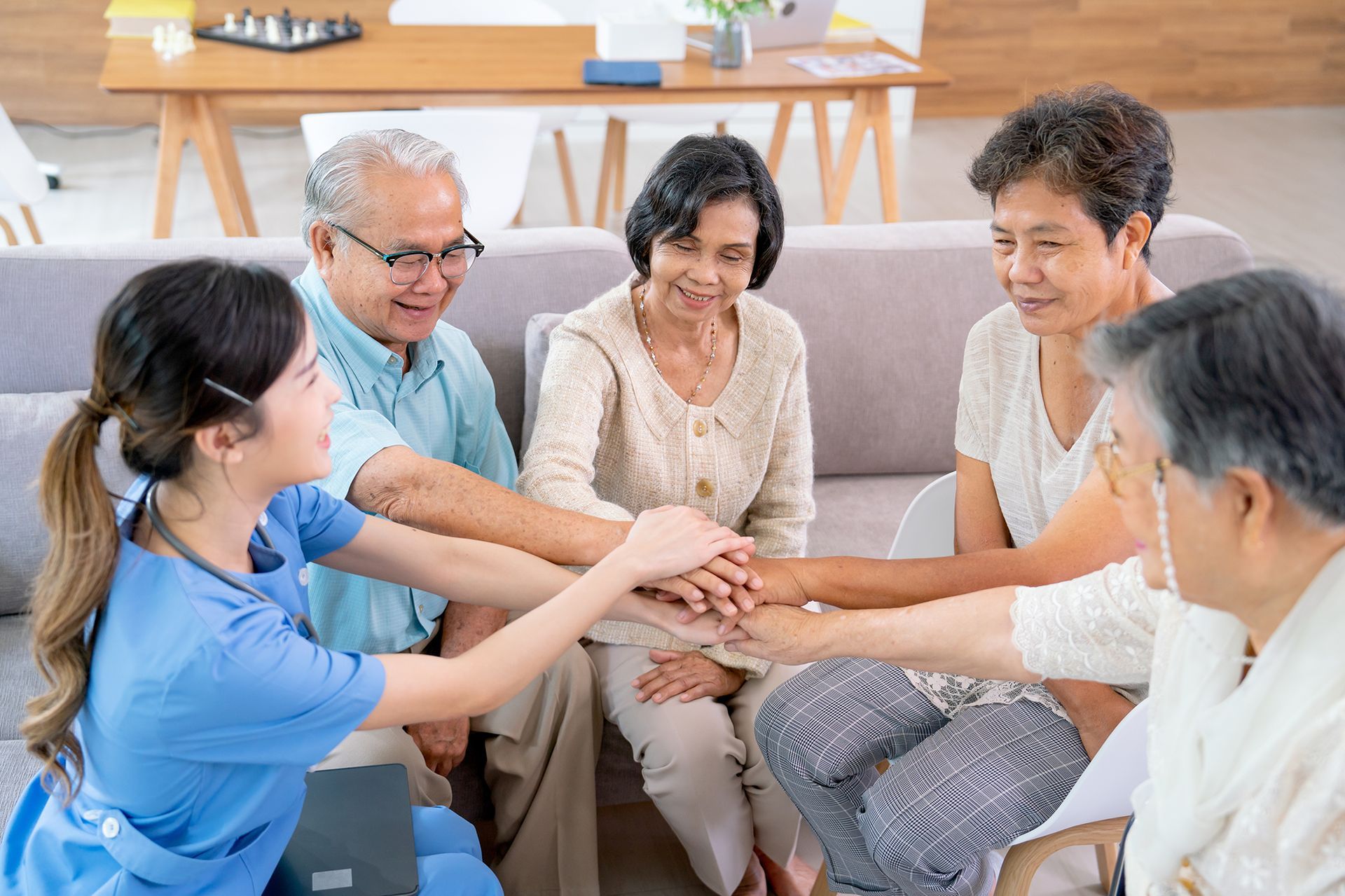A group of elderly people are putting their hands together in a huddle