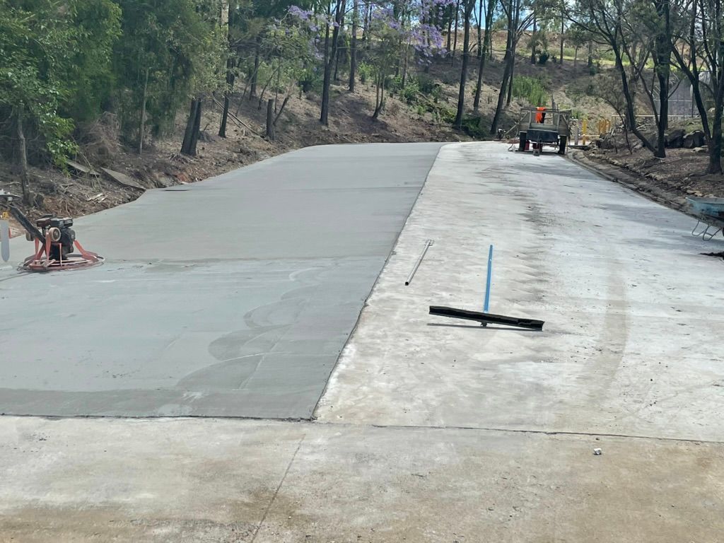 Concrete Road Being Finished With Machinery and Tools — Asphalt & Concreting Services & Solutions in Logan Village, QLD

