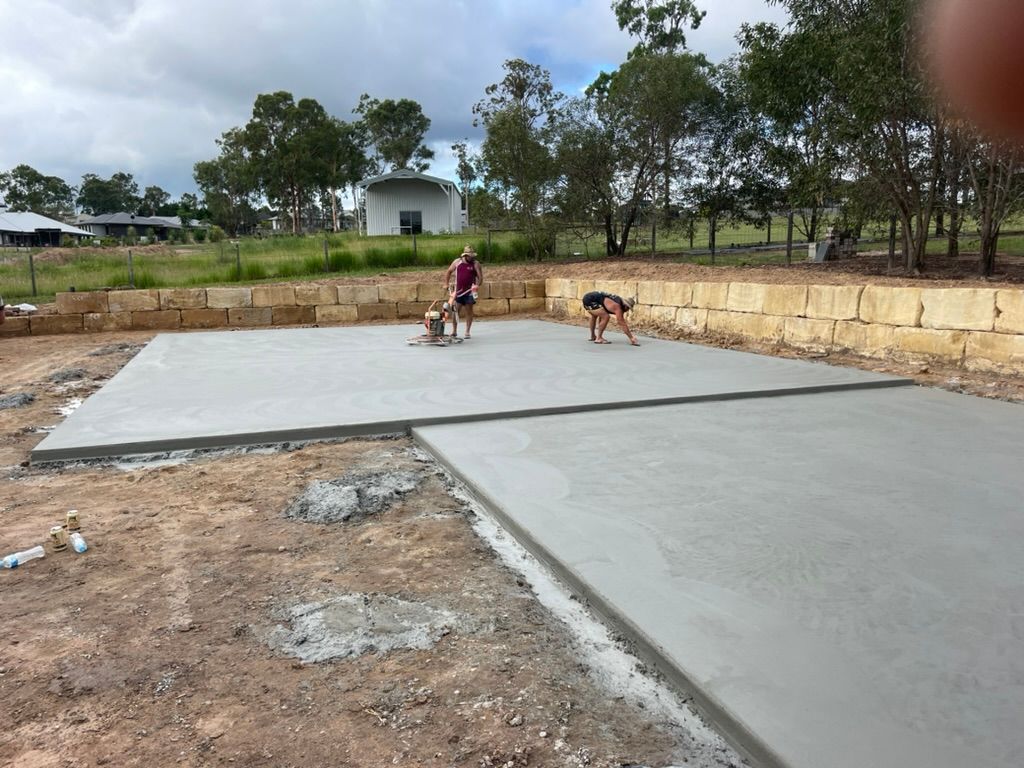 Workers Finishing a Concrete Slab in an Outdoor Setting — Asphalt & Concreting Services & Solutions in Logan Village, QLD
