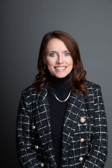 A man and a woman are sitting on a dock overlooking a lake.