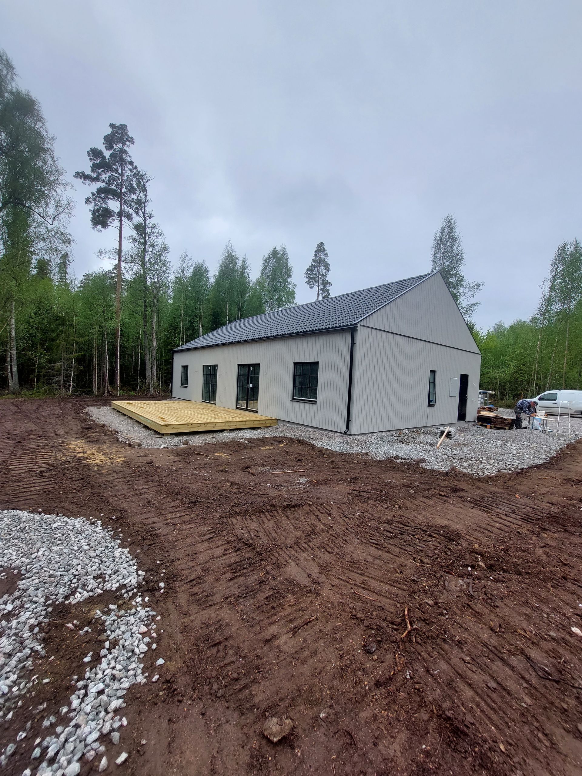 Ett hus byggs mitt i ett jordfält.
