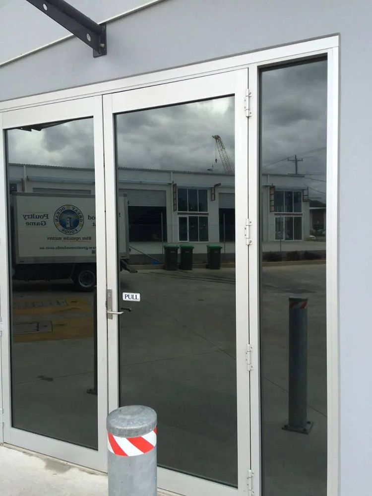 A White Truck is Reflected in the Glass Doors of a Building — Endrust (Coffs Harbour) in Coffs Harbour, NSW