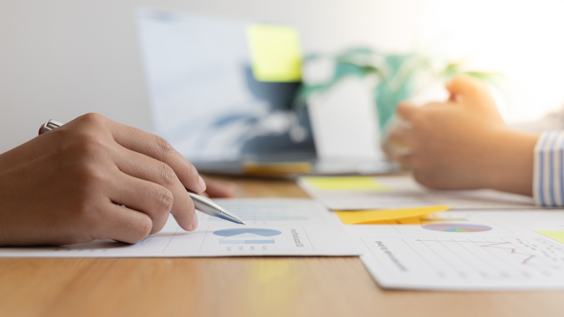 A person is writing on a piece of paper with a pen.