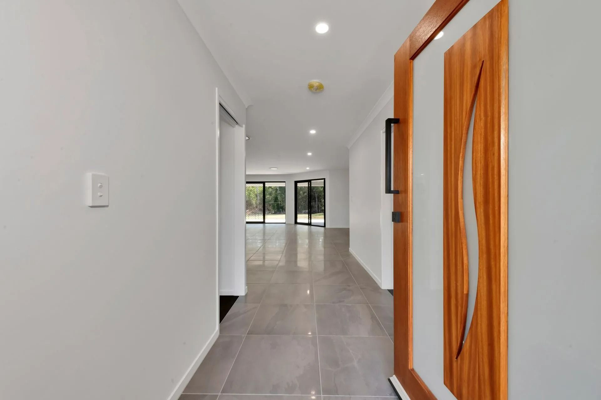 A Hallway with A Wooden Door Slightly Ajar, Leading to A Living Area — Country to Coast Homes In Gregory River, QLD