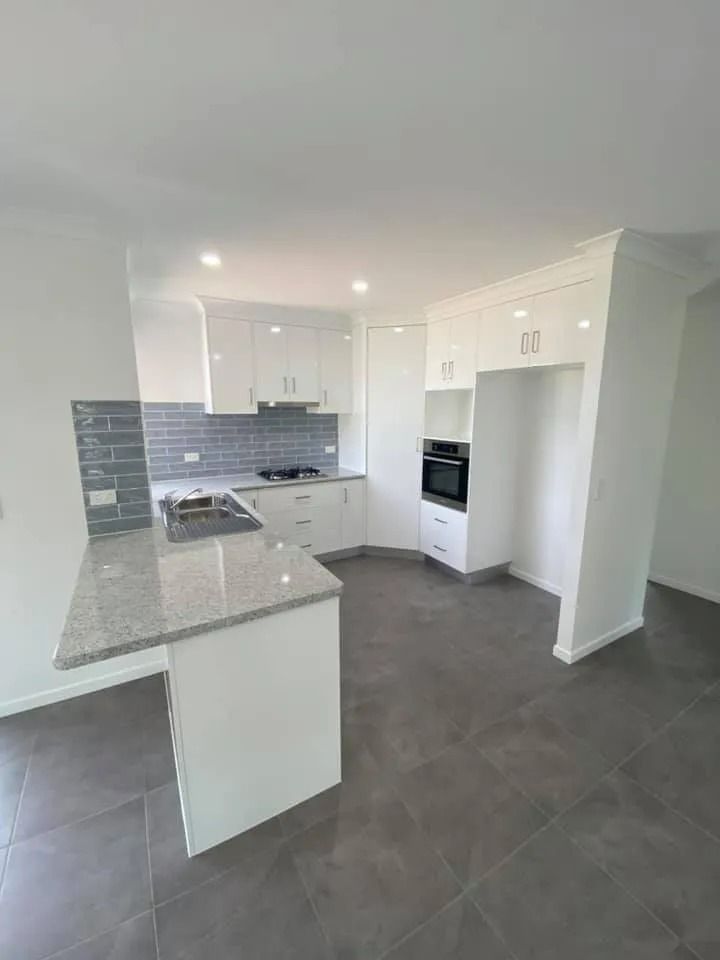 White Modern Kitchen with Gray Countertop and Tile Backsplash — Country to Coast Homes In Gregory River, QLD