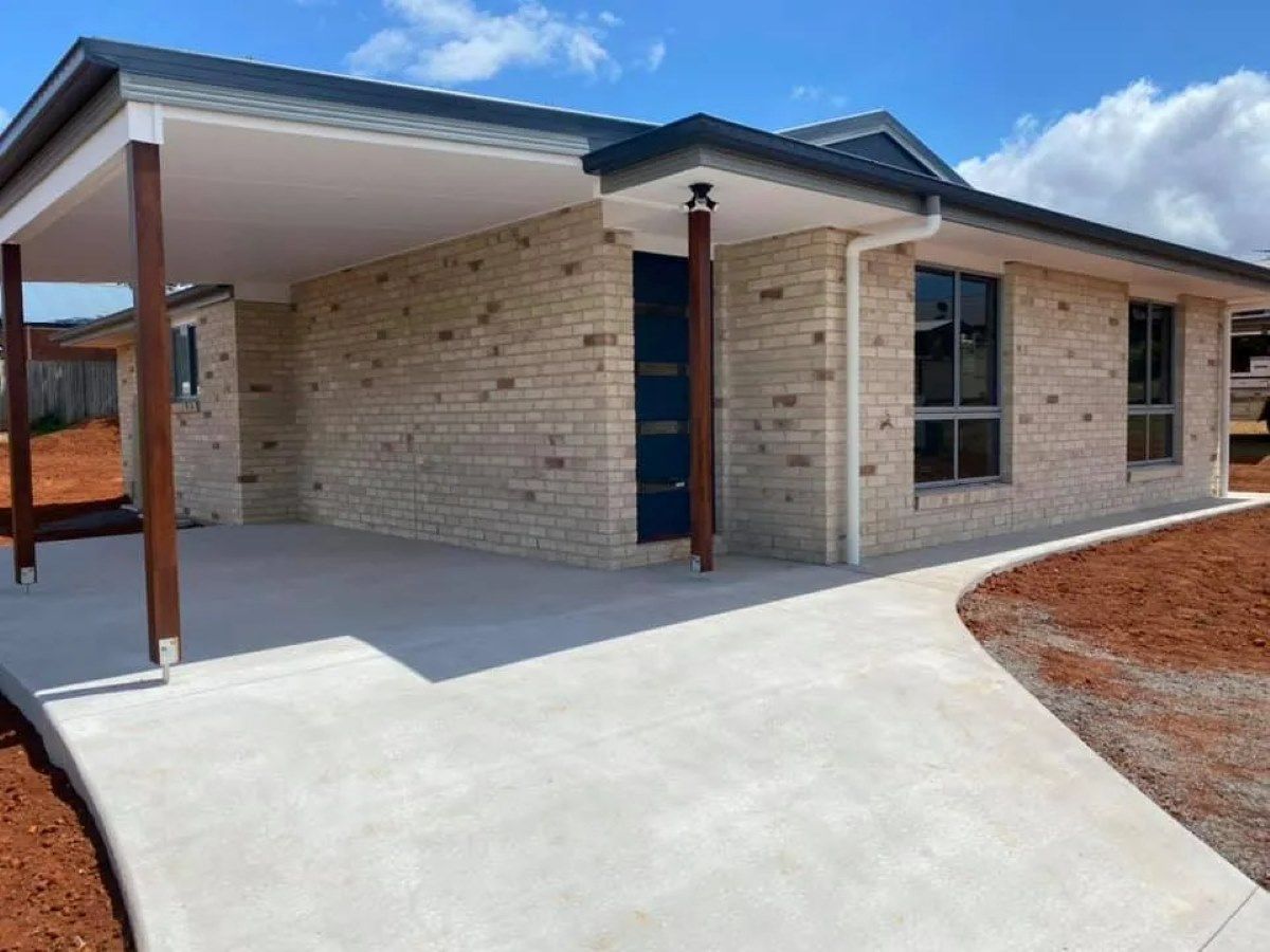 A Single-Story Brick House with A Carport, Concrete Driveway — Country to Coast Homes In Gregory River, QLD