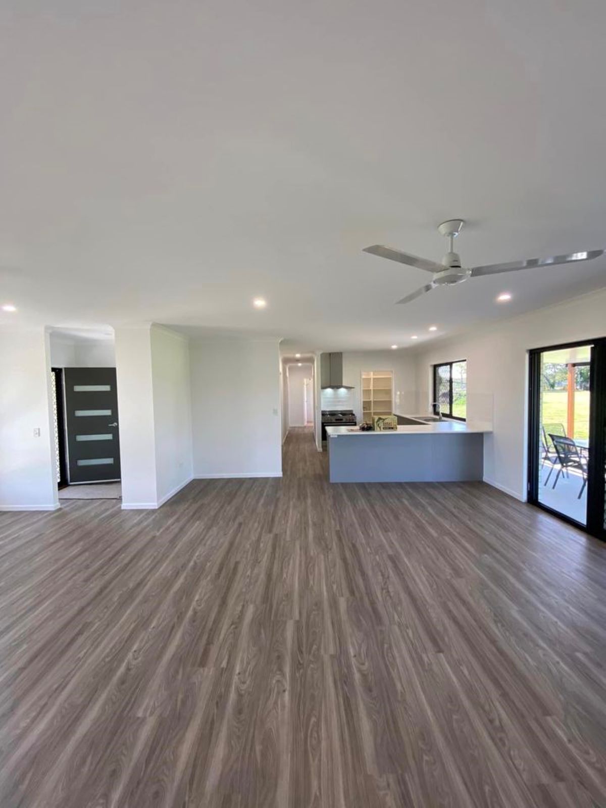Wood-Look Flooring, White Walls and Ceiling, Kitchen with Grey Island — Country to Coast Homes In Gregory River, QLD