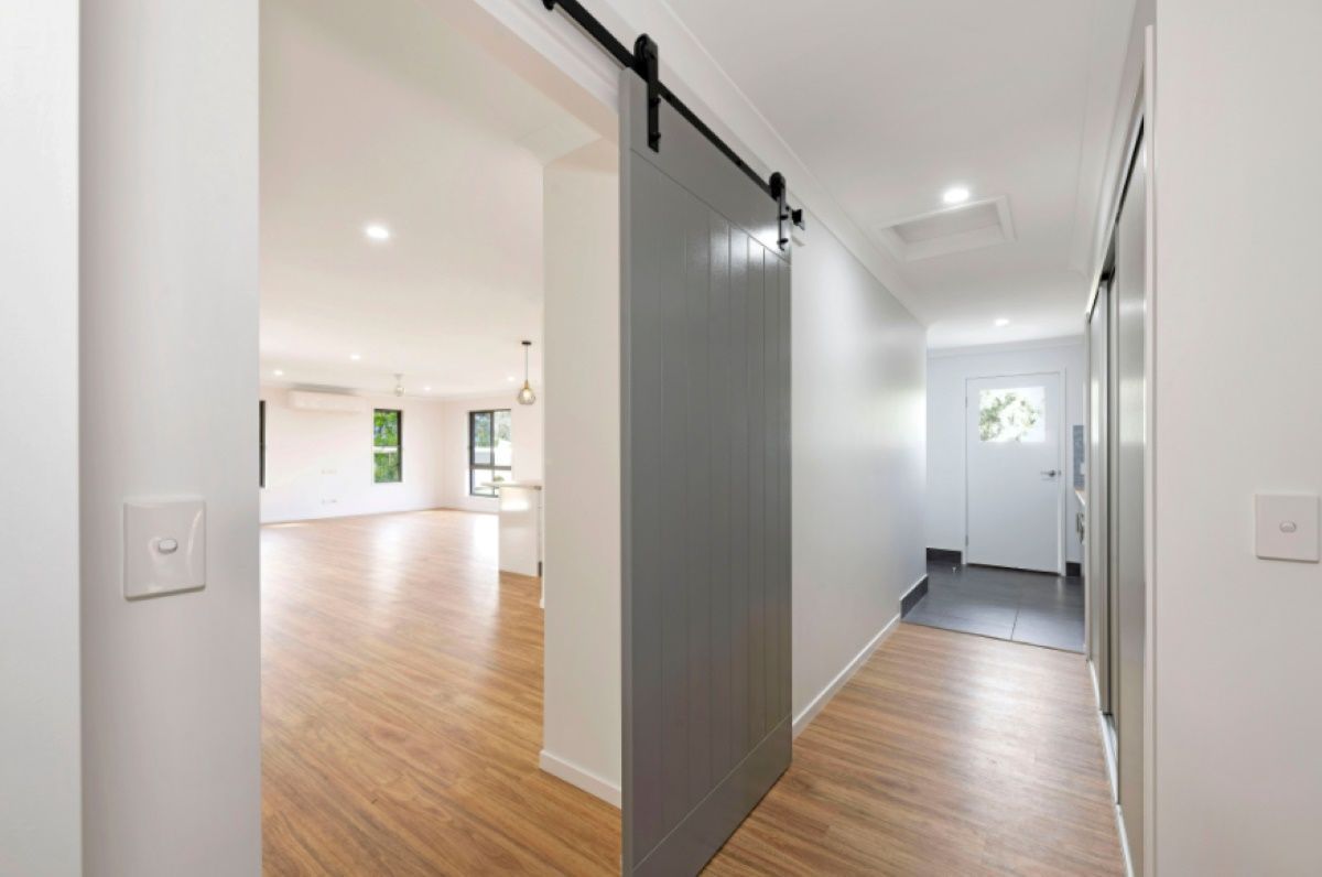 Interior Hallway with A Gray Sliding Barn Door — Country to Coast Homes In Bundaberg, QLD