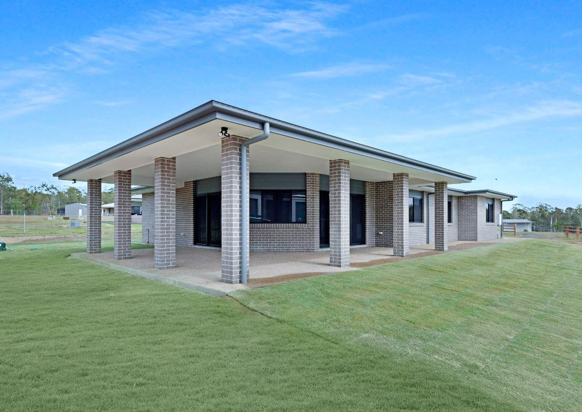 A Modern, Single-Story House with A Large Covered Patio, Brick Columns — Country to Coast Homes In Childers, QLD