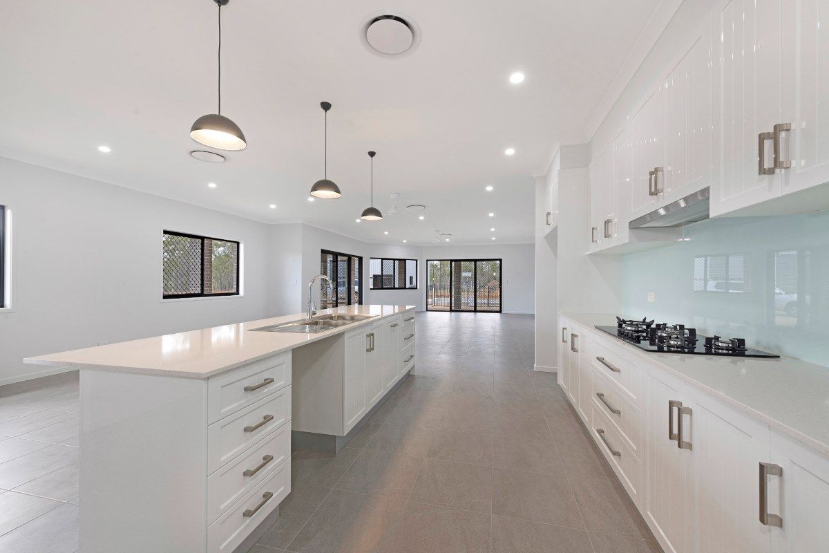 Bright, White Modern Kitchen with A Large Island, Matching Cabinets — Country to Coast Homes In Childers, QLD