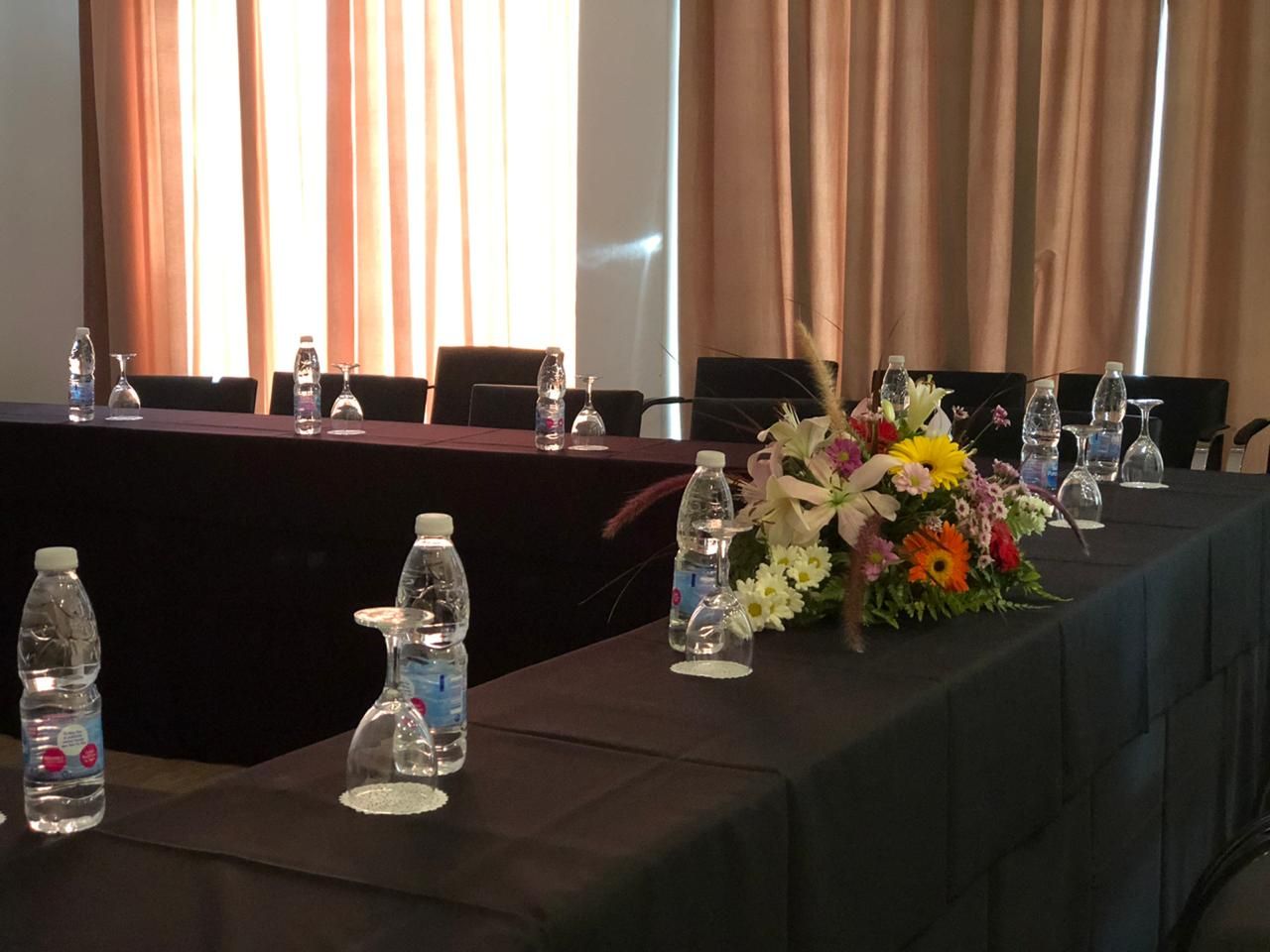 A long table with water bottles and glasses on it