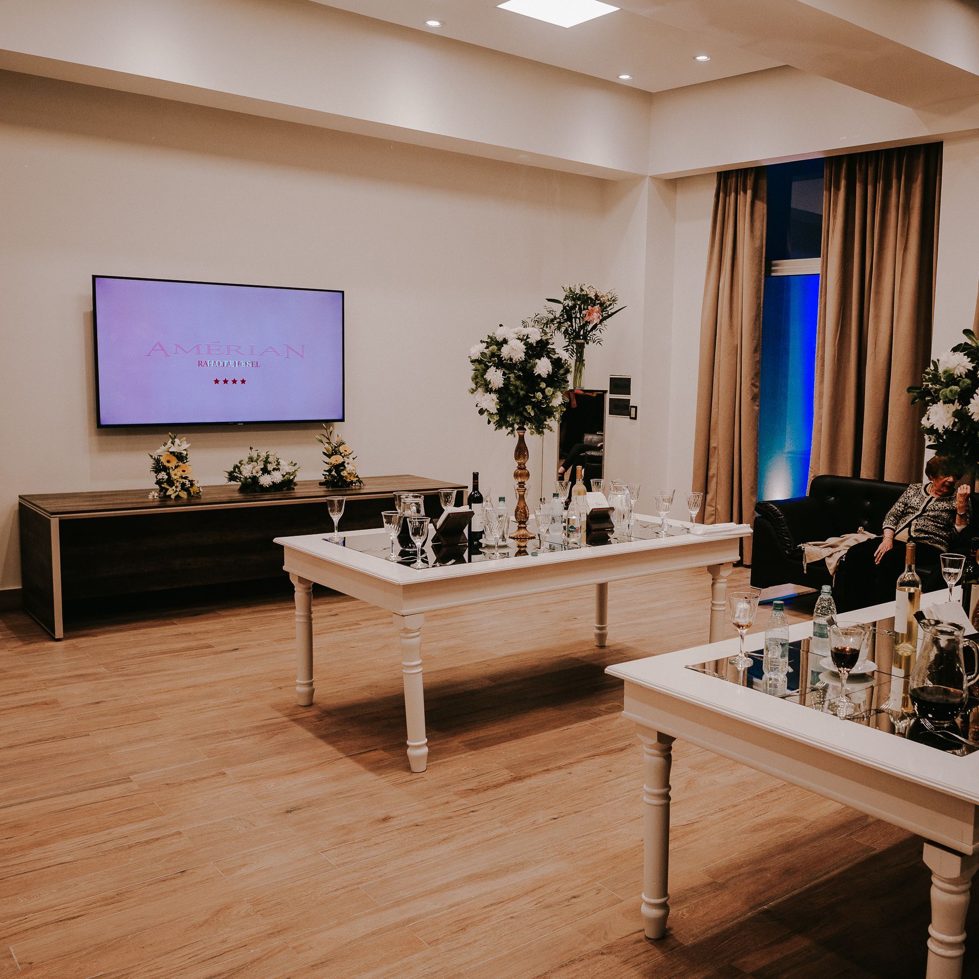 A living room with tables and a flat screen tv