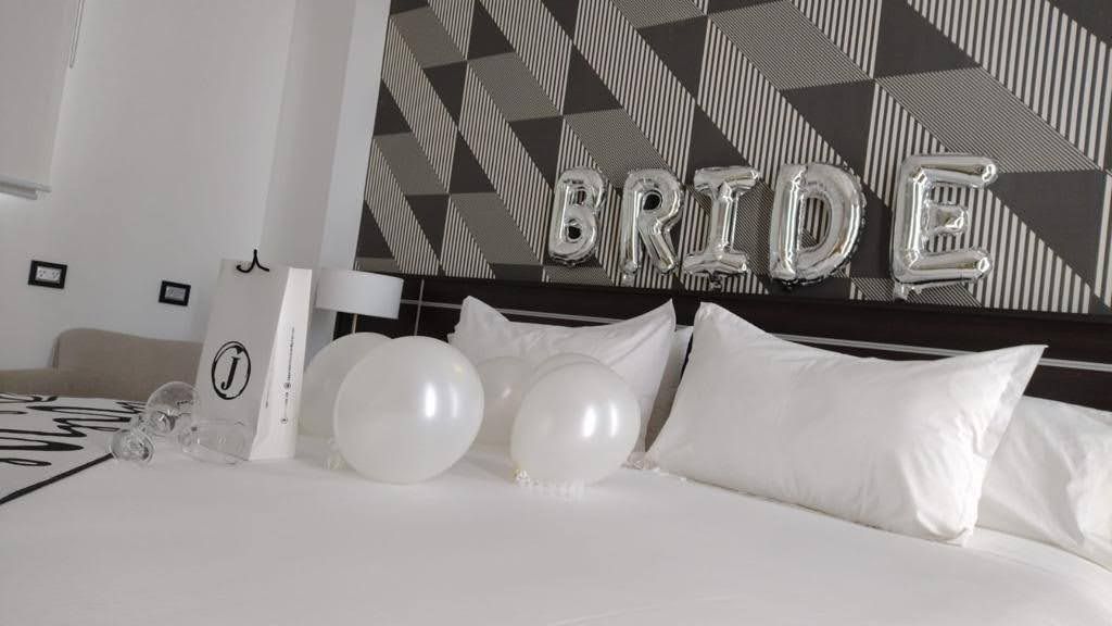 A bed with balloons and the word bride written on it.