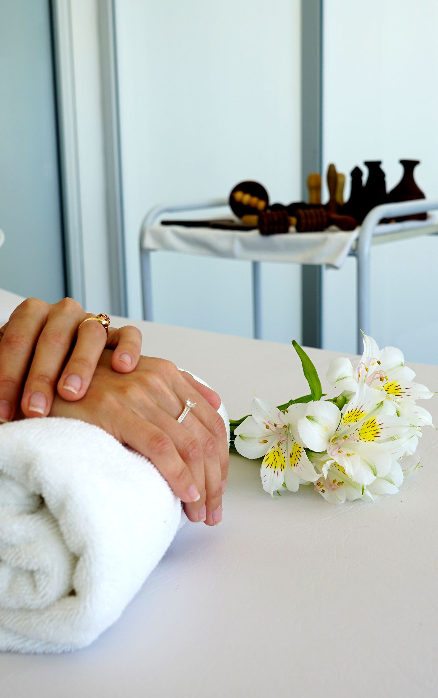 A person holding another person 's hand next to a towel and flowers