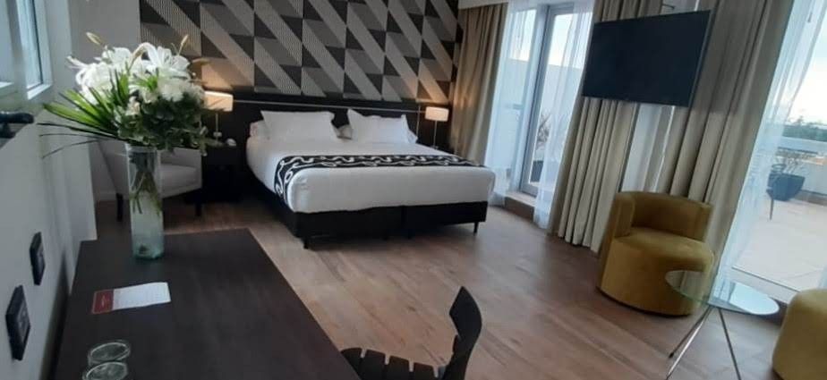 A hotel room with a large bed , desk , chair and television.