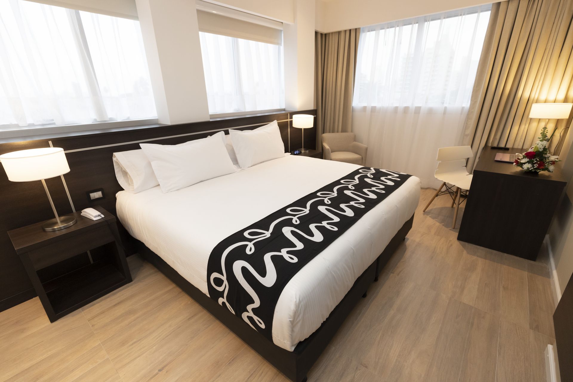 A hotel room with a king size bed and a desk
