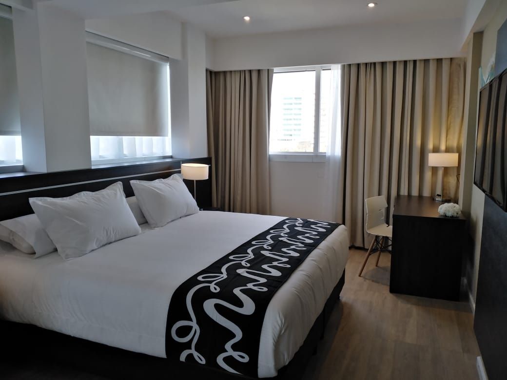 A hotel room with a large bed and a desk