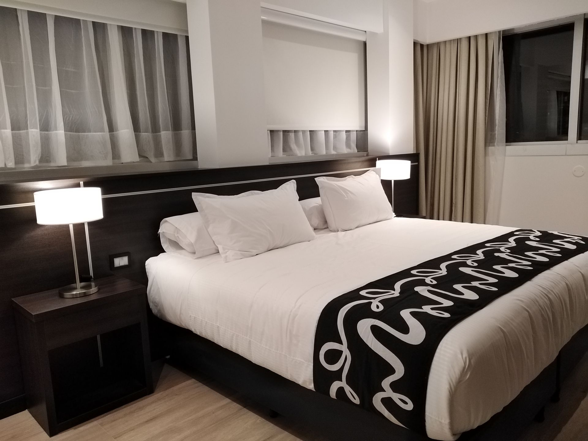A hotel room with a king size bed and two nightstands