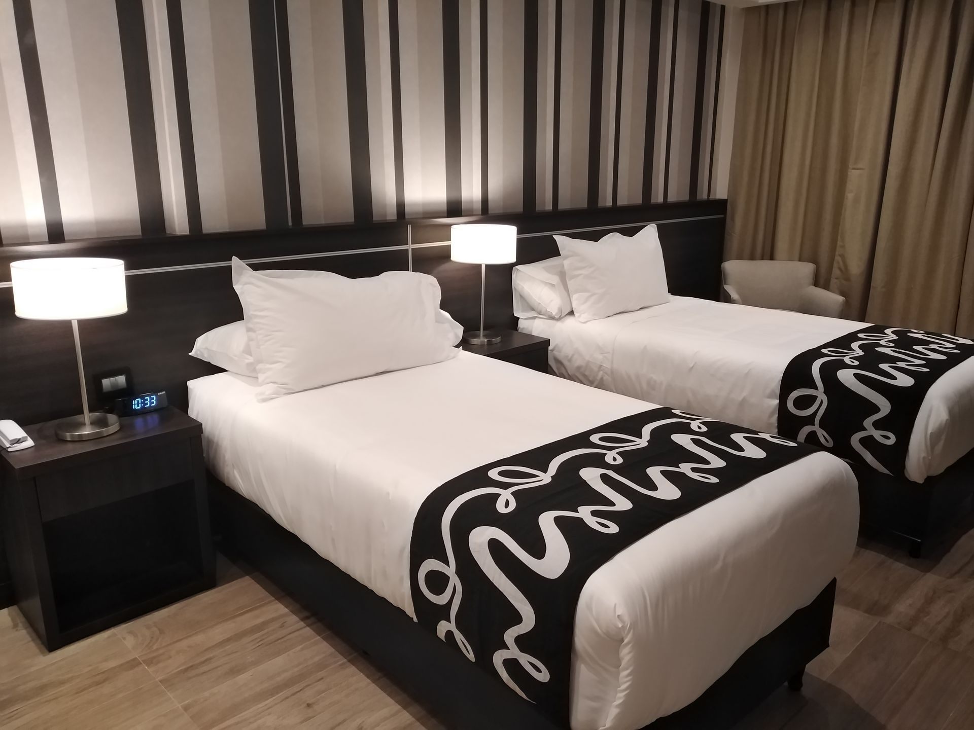 A hotel room with two beds and a chair