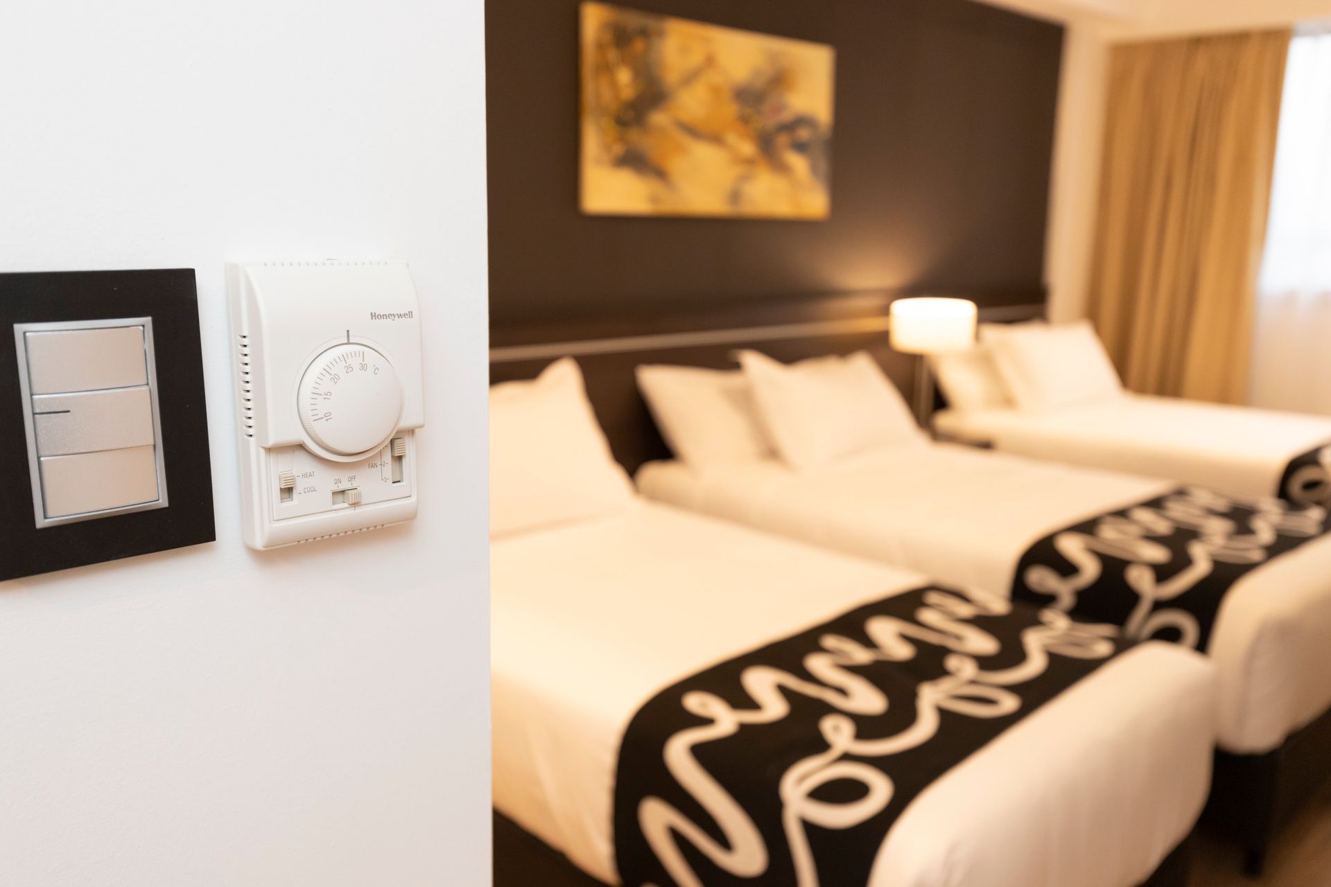 A hotel room with two beds and a clock on the wall.