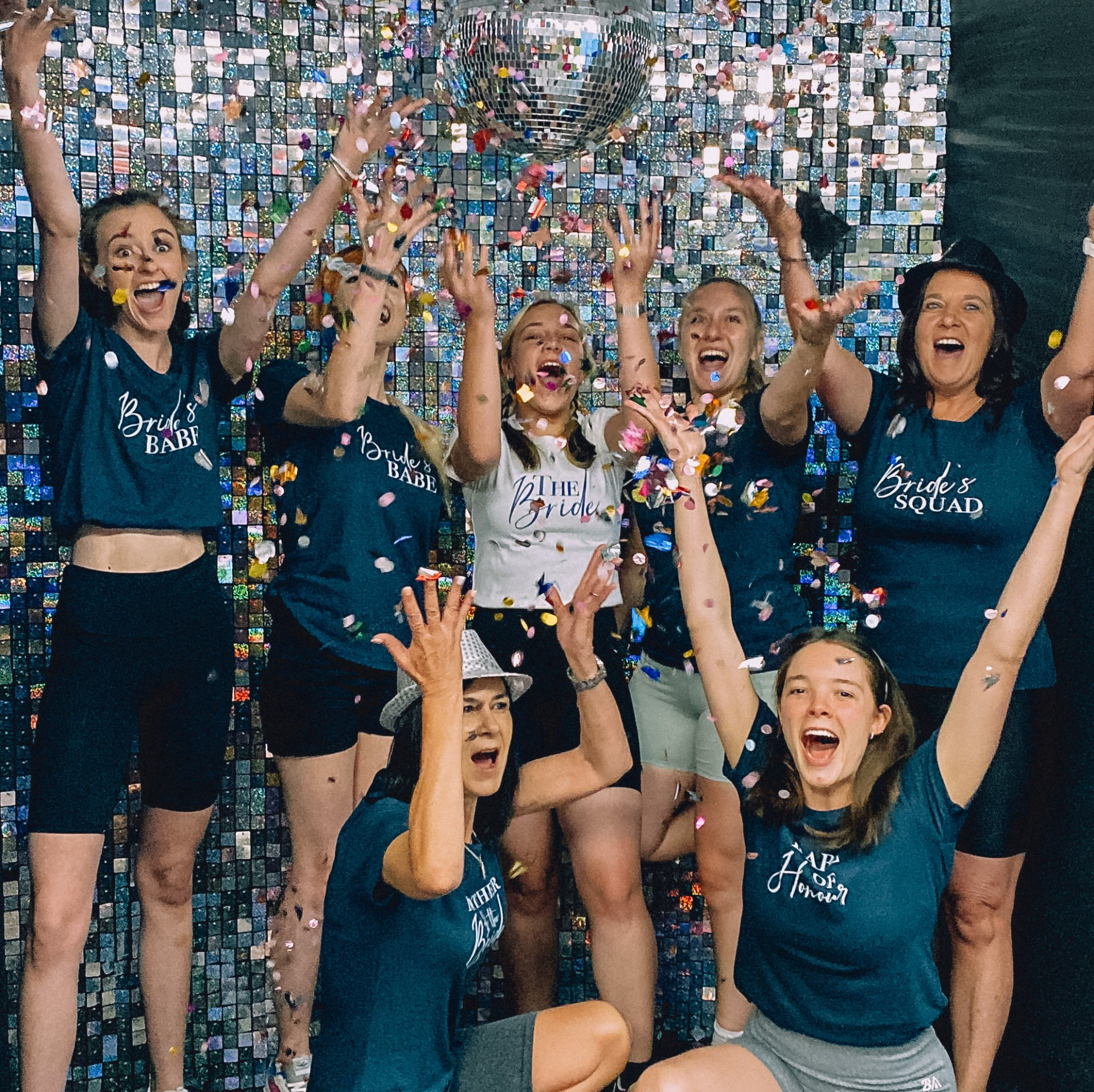 Group of girls throwing confetti in celebratory shout