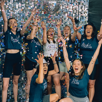 Group of girls throwing confetti in celebratory shout