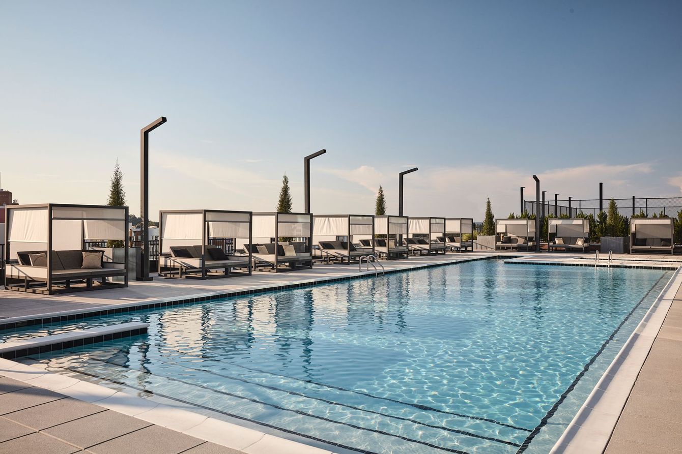 An aerial view of a building with a pool on the roof