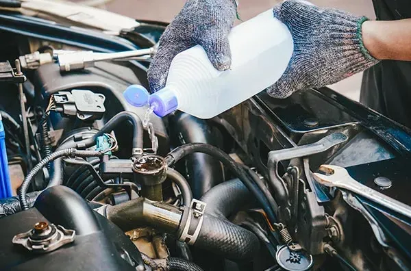 A Person Is Pouring Water Into a Car Engine β Wyong Radiator Repairs in Tuggerah, NSW