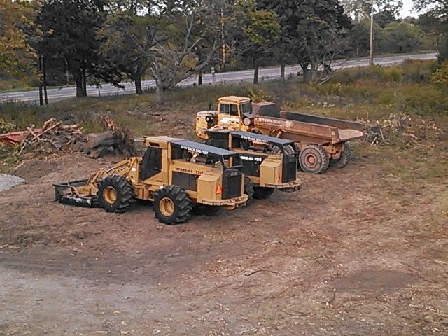 Two tractors are parked next to each other in a dirt field