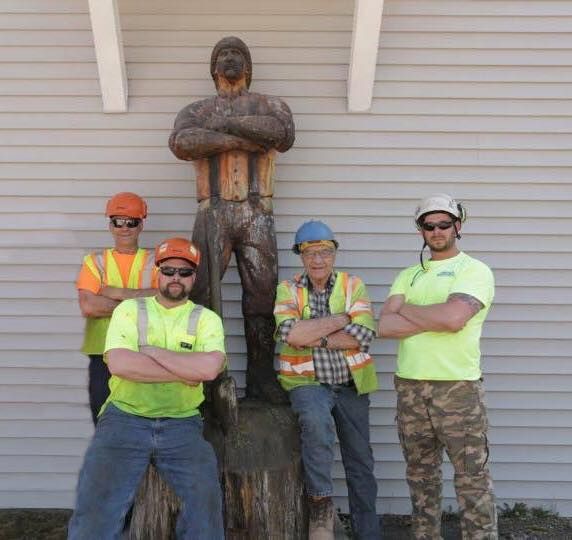 A group of construction workers standing in front of a statue