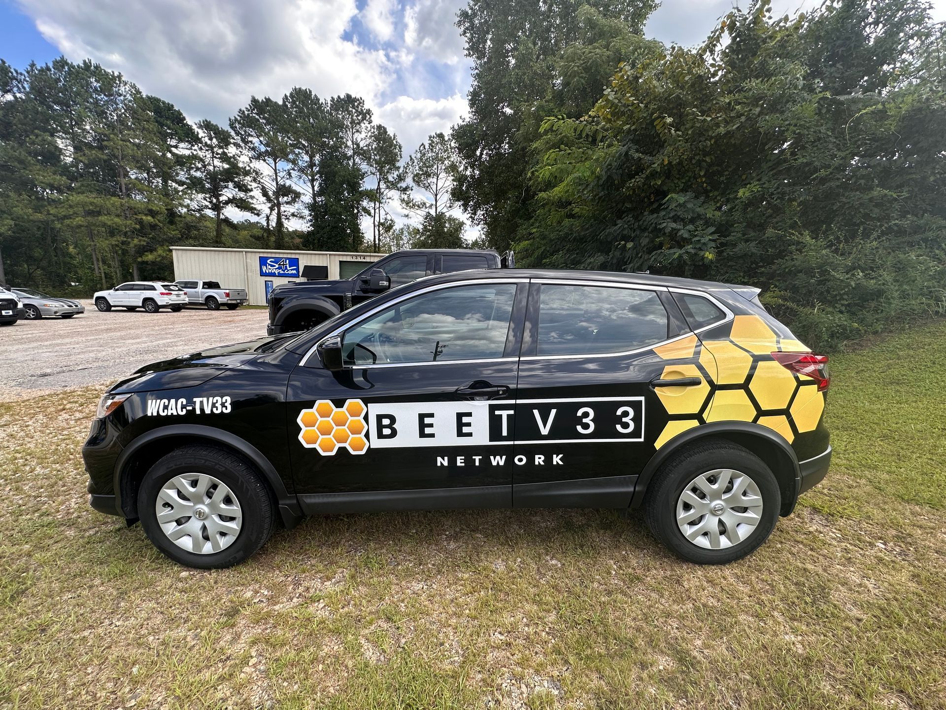 partial custom printed commercial wrap in black with white and yellow logos and graphics