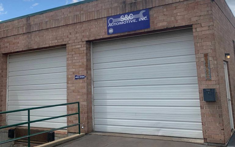Exterior of S&G Automotive, a brick building with two closed garage doors and a sign above | S&C Automotive Inc