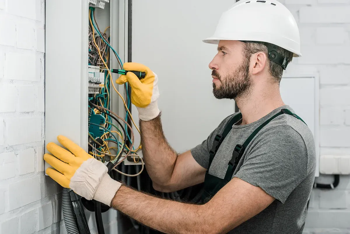 Electrician inspecting a burnt socket during an emergency call-out in a London home