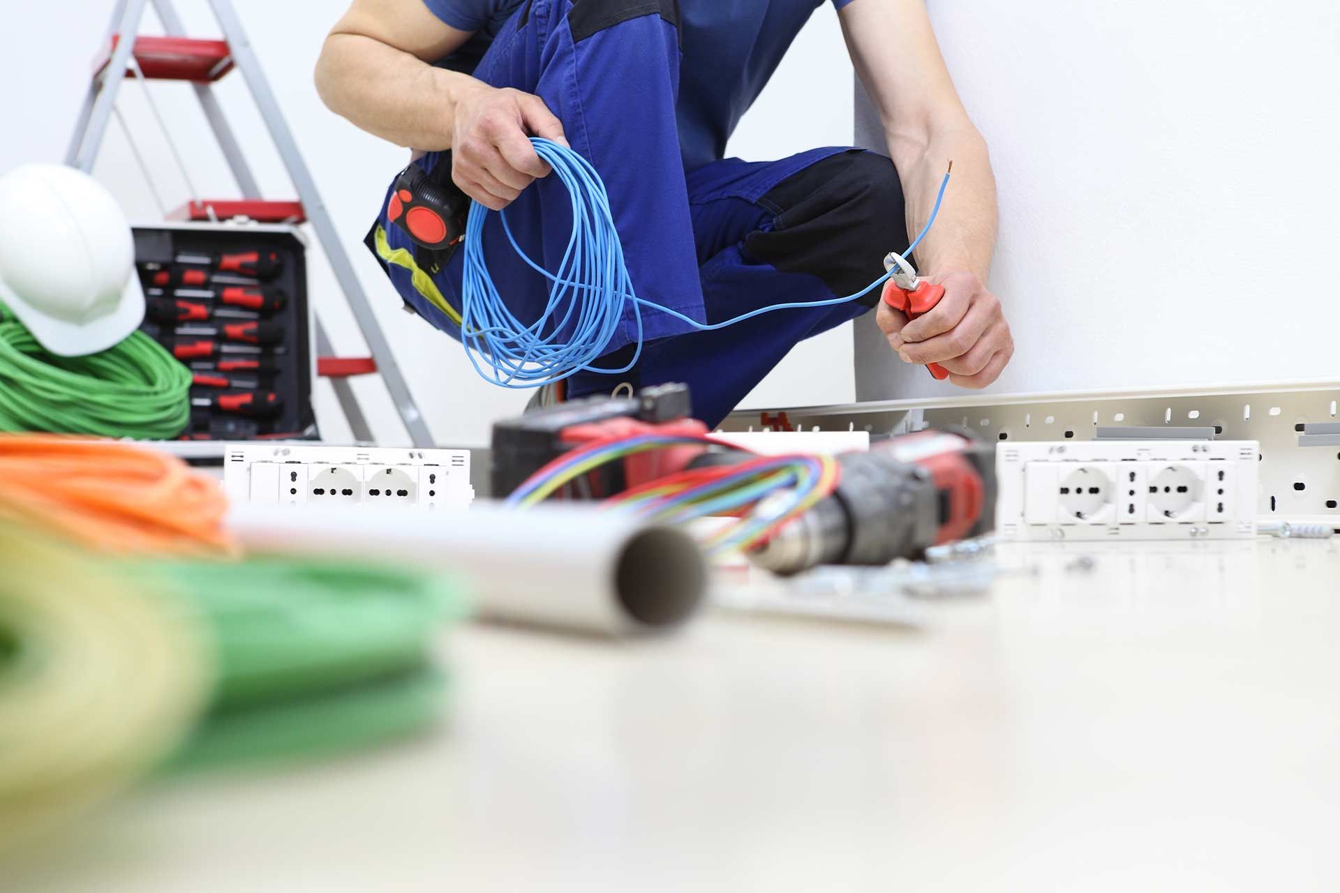 Electrician rewiring a home in London with exposed wiring and circuit layout in progress