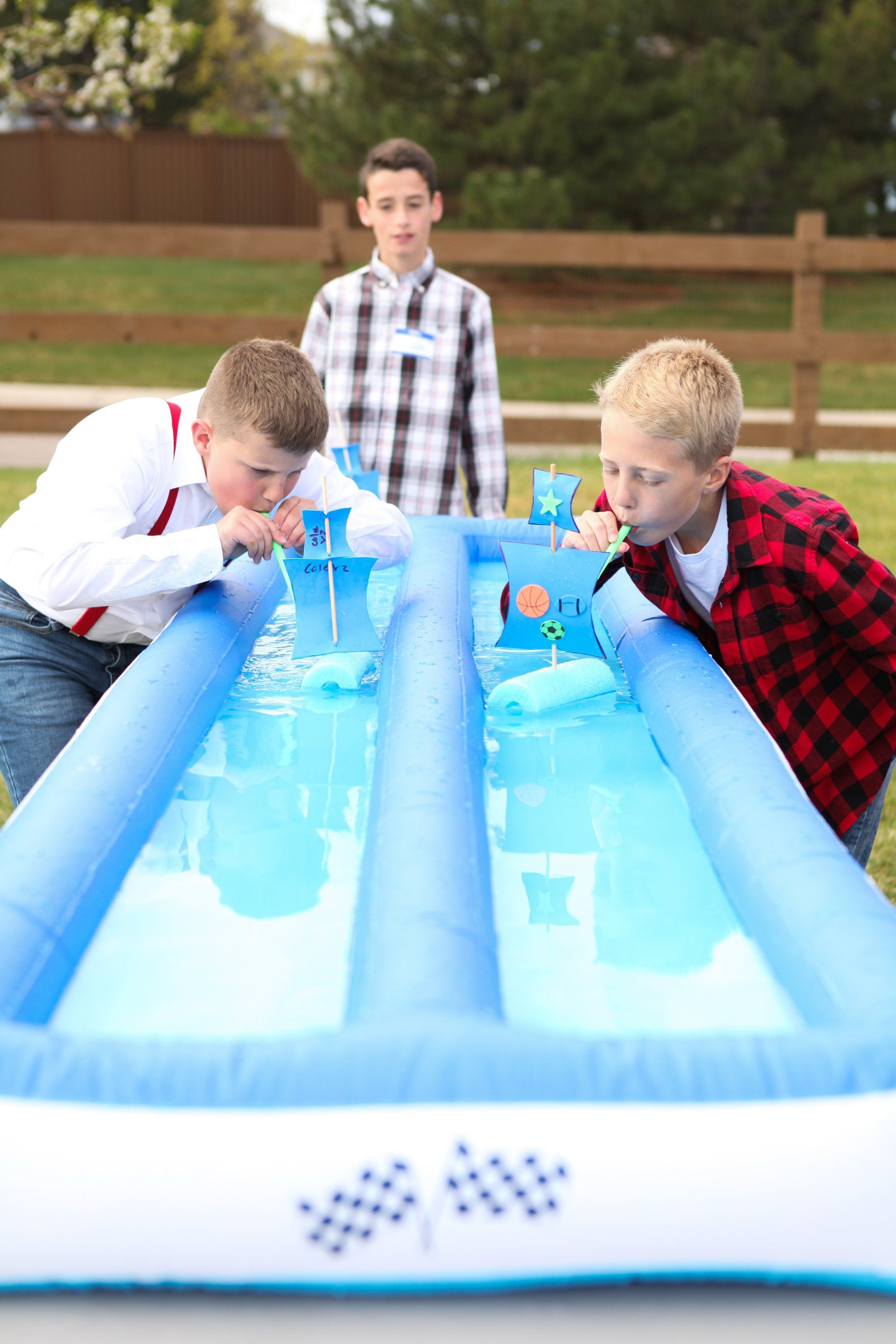 A group of young boys are playing a water slide.