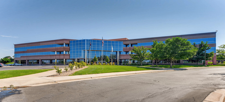 A large office building with a lot of windows and trees in front of it.