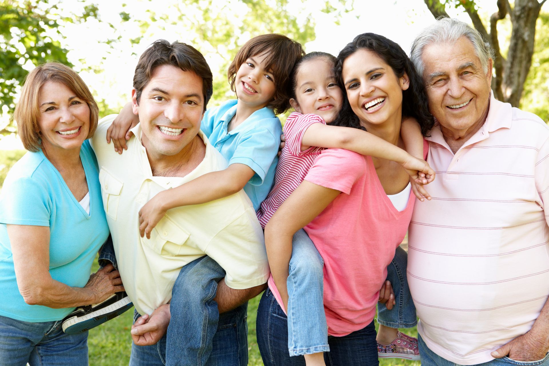 Multi-Generation Hispanic Family Standing In Park