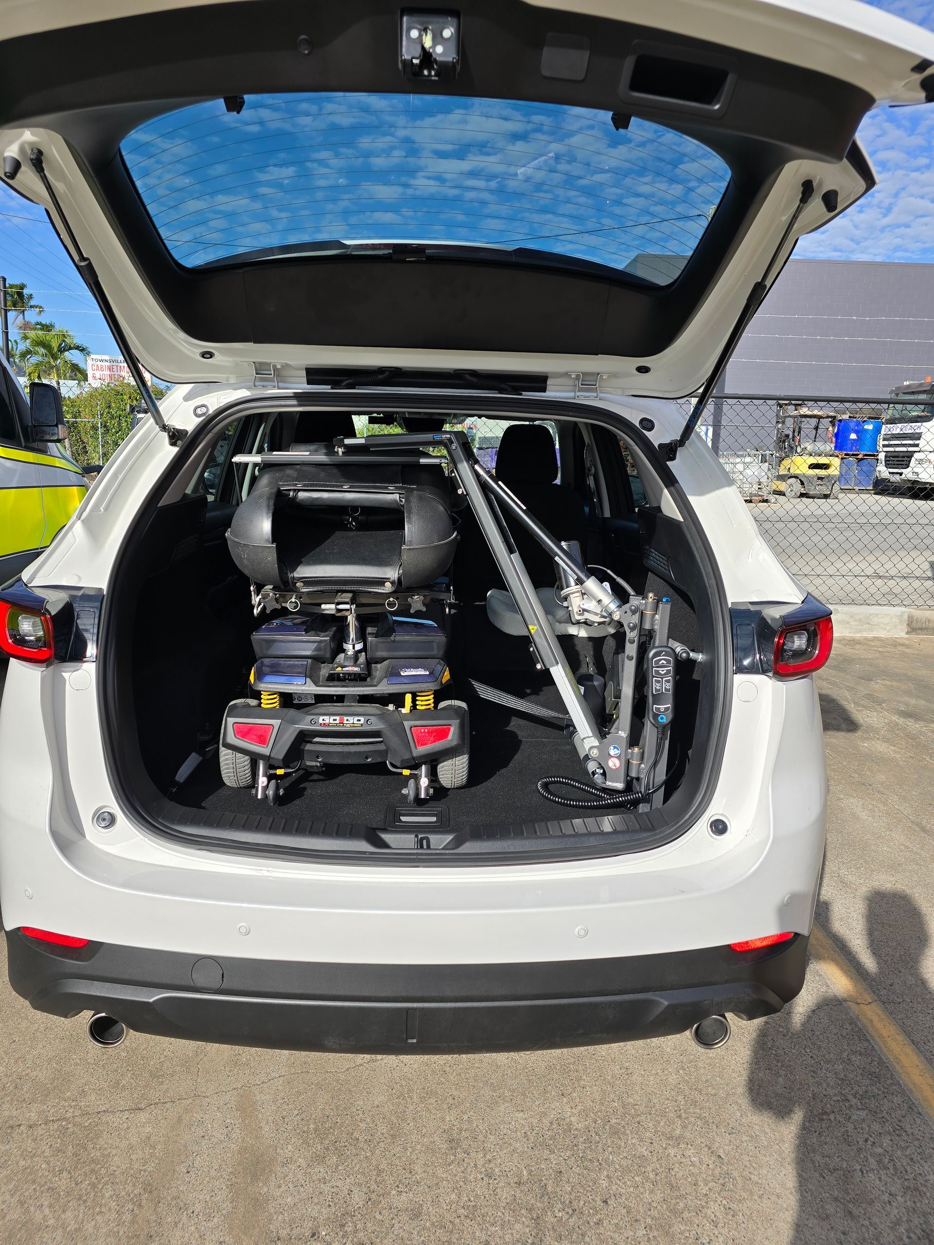 A Wheelchair Is Kept in The Back of A Car — Mobility Modification Services In Garbutt, QLD