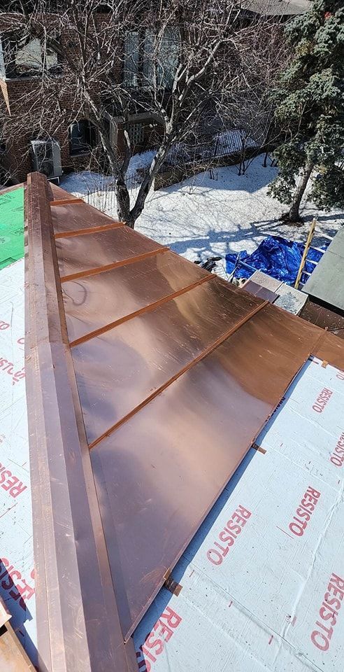 Un toit en cuivre est en cours d'installation sur une maison.