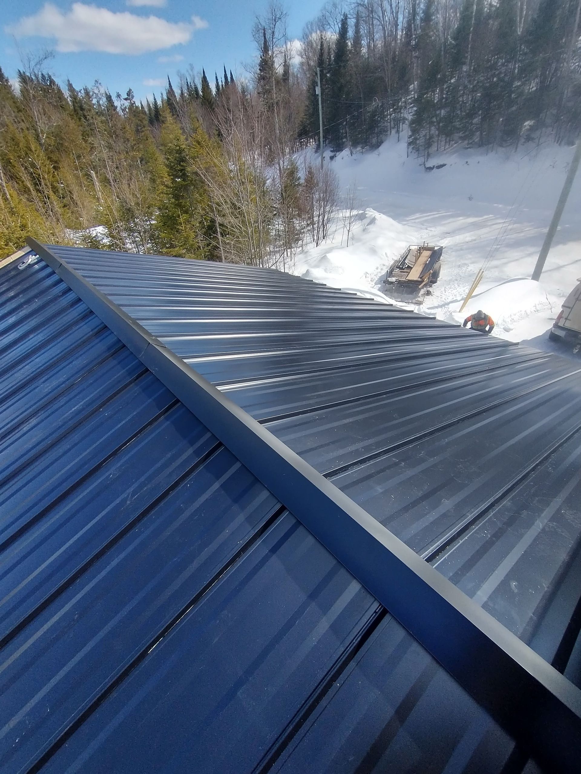 Un toit noir avec un paysage enneigé en arrière-plan