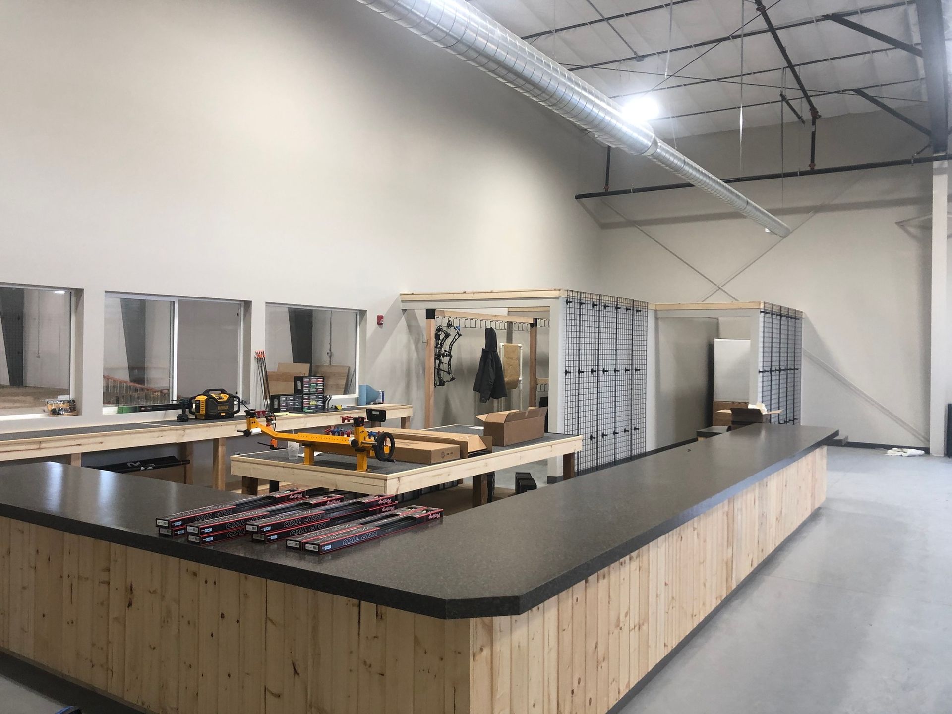 Interior of a retail space under construction, featuring a wooden counter, mirrors, and unfinished walls.