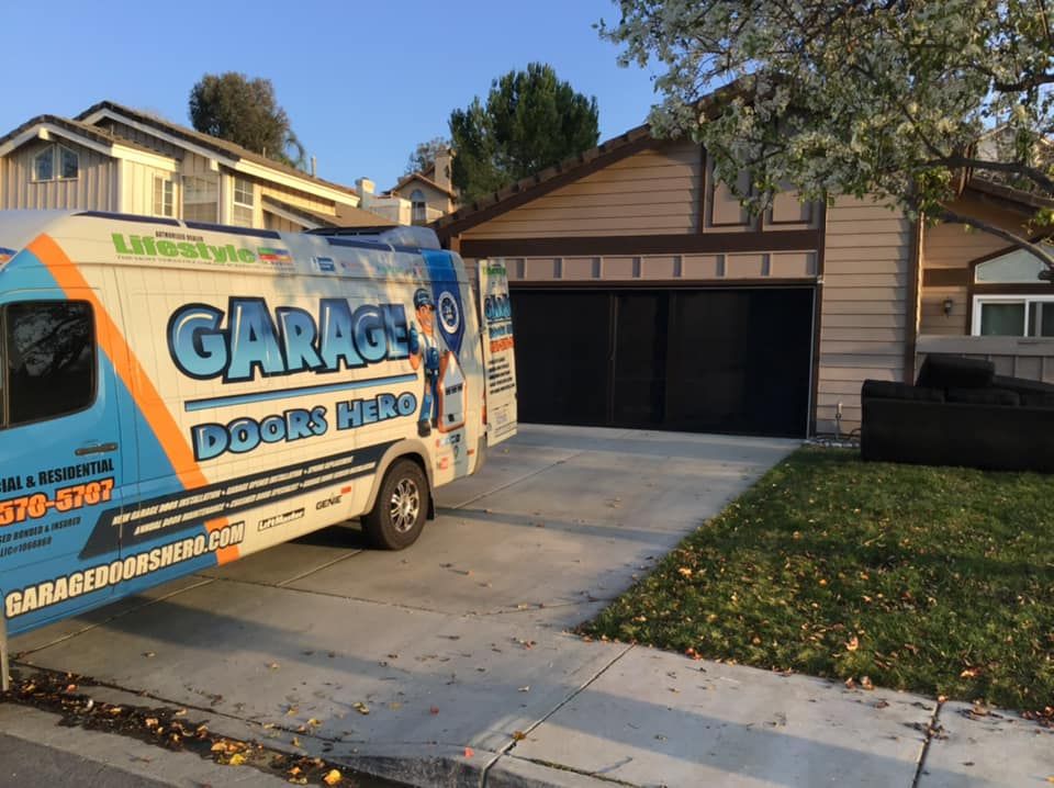 A garage doors truck is parked in front of a house