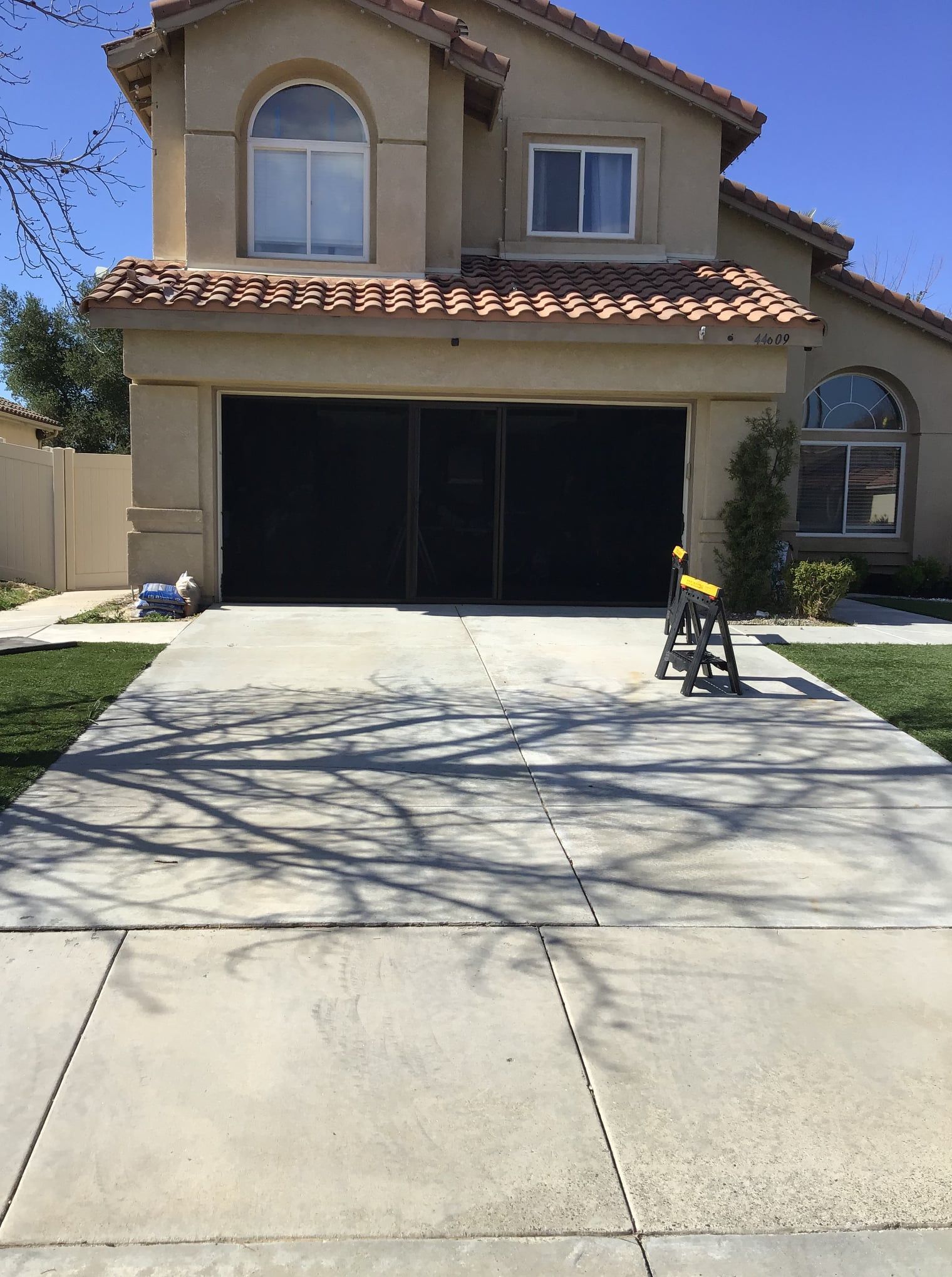 A house with a black garage door and a concrete driveway