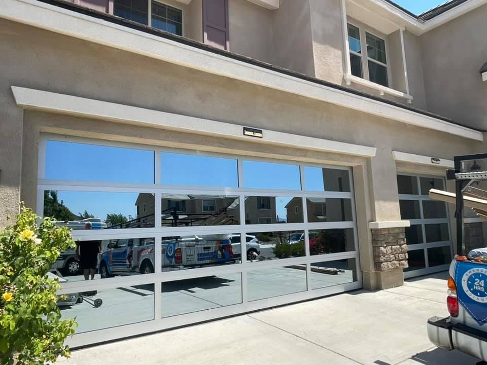 A white truck is parked in front of a large garage door.