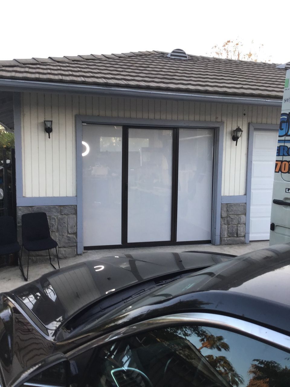A black car is parked in front of a house