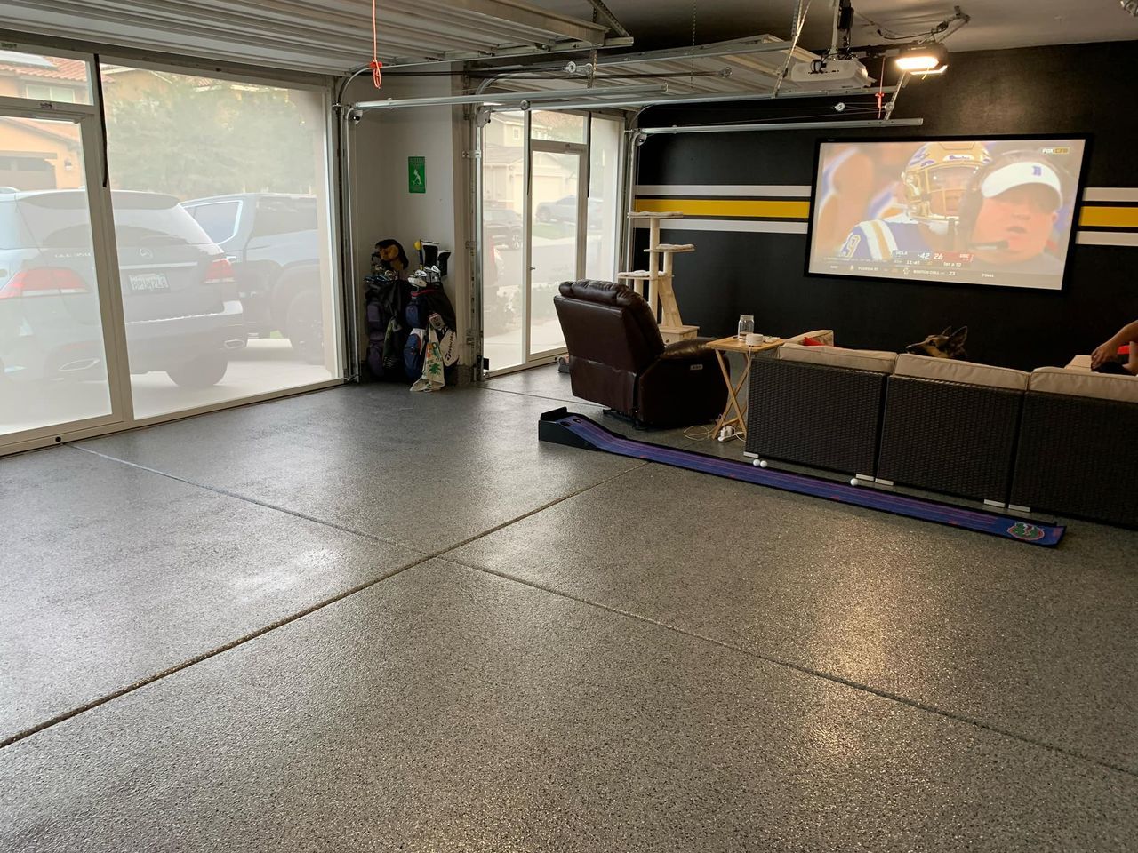 A living room in a garage with a couch and a television.